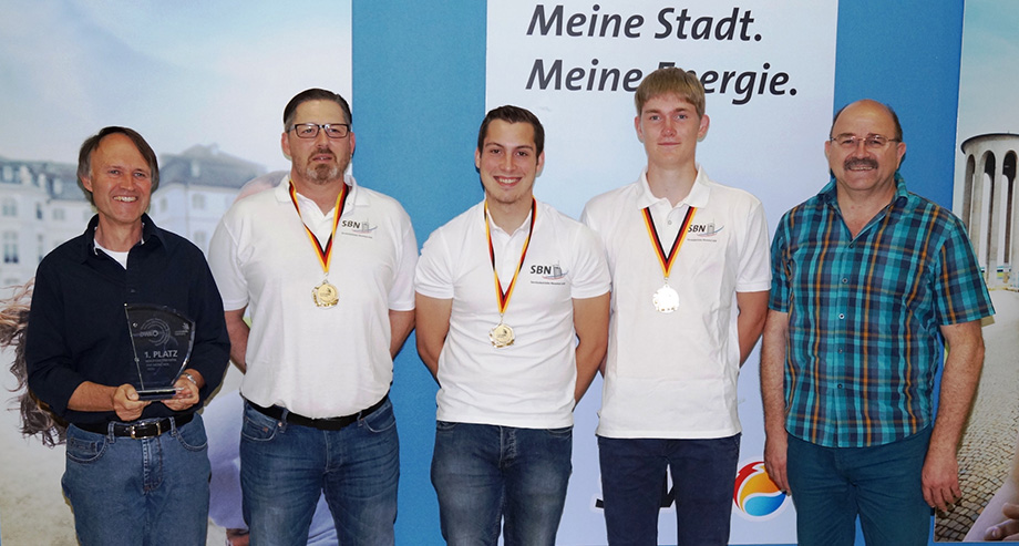 SBN-Geschäftsfeldleiter Klaus Gerhardt freut sich über die Trophäe, die Mariano Franz, Maximilian Specht und Patrick Gundert mit ihrem Ausbilder Andreas Brubach in München erkämpften.